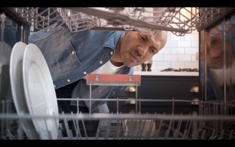 Man Looking Inside a Dishwasher